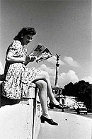 Auch in den Trümmern ging das Leben weiter. Das Bild aus dem Sommer 1946 zeigt eine junge Frau, die mit einer Illustrierten auf der Münchner Prinzregentenbrücke die Sonne genießt. Foto: Bayer. Pressebild / Haus der Bayerischen Geschichte