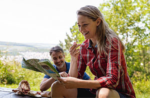 Radfahrerpaar bei der Rast, die Tourenkarte studierend