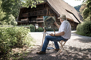 Der erfahrene Kunstmaler Wolfram Paul aus Altensteig (Bild links, Foto: Schwarzwälder Freilichtmuseum Vogtsbauernhof, Iuliu Sebastian Wagner) nimmt am Samstag, den 12. August, in die Welt der Freilichtmalerei mit.