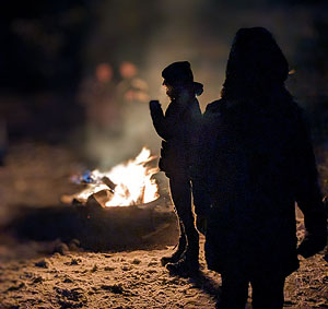 Dunkle Figuren vor dem Feuer